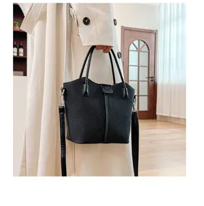 Detail view of black canvas handbag, casual top-handle tote bag with stylish shoulder strap.