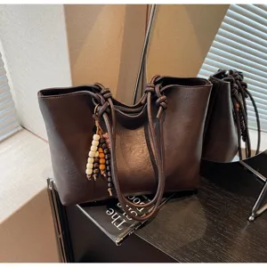 Retro brown PU leather tote bag with knotted straps and wooden bead charm for daily commute.