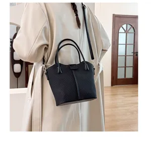 Stylish black canvas shoulder bag for women, casual tote with top handles and cross body strap.