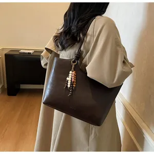 Detail view of dark brown minimalist tote bag, large capacity retro shoulder bag with beads.