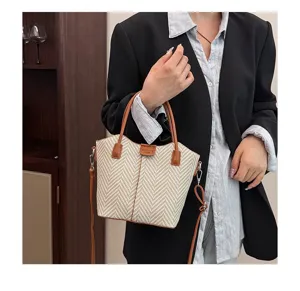 Chic woven shoulder handbag detail view, featuring stylish brown leather trim and long strap.