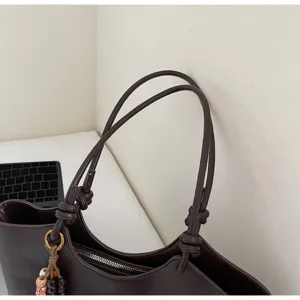 Simple dark brown leather tote bag with knotted straps and beaded pendant for women daily commute.