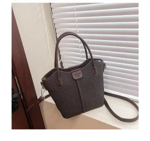 Detailed shot of casual brown herringbone tote bag showcasing texture and daily styling.