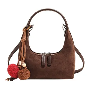 Brown suede hobo dumpling bag retro shoulder crossbody bag with cute pom-pom pendant.