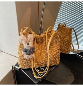 Brown plush shoulder bag detail shot featuring a cute bear pendant and stylish caramel aesthetic.