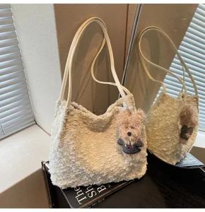 Detail view of cute plush shoulder bag showing soft fluffy texture and adorable bear pendant.