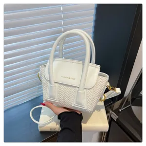 Bolso de mano trenzado blanco con asa, solapa elegante y textura detallada para uso diario.