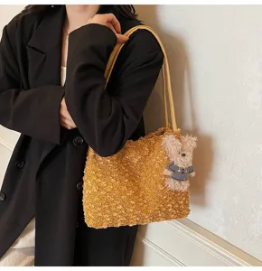 Detail view of retro Maillard style plush shoulder bag with cute fluffy bear pendant accessory.