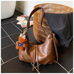Detailed view of the stylish autumn winter PU leather shoulder hobo bag with cute bear pendant.