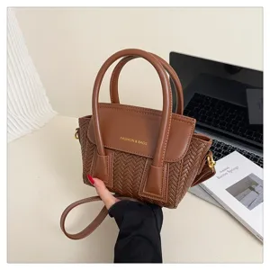 Bolso de mano tejido marrón en detalle, muestra superficie texturizada y elegante diseño.