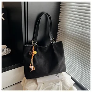 Schwarze Wildleder-Tragetasche mit Hohlblumenmustern und Perlenanhänger, elegante Schultertasche.
