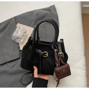 Women's vintage suede handbag with buckle strap detail, versatile crossbody shoulder bag.
