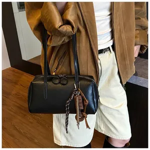 Detailed view of the black PU leather bowling shoulder bag featuring stylish charms and dual straps.