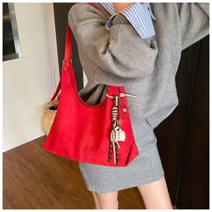 Close-up shot of the casual red suede shoulder bag with chic coffee cup pendant detail.