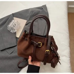 Brown suede handbag with top handle and buckle design, chic cross body style for women.