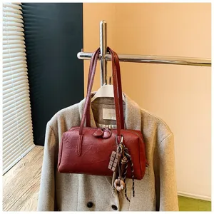 Retro dark red PU leather bowling shoulder bag detail shot with cute chocolate charm pendant.