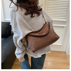 Detailed view of brown suede underarm shoulder bag with large capacity and stylish design.
