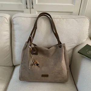 Vintage suede shoulder bag for women, large capacity commuting tote bag with chic charm.