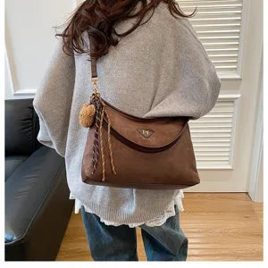Brown suede shoulder bag with tassel pendant, stylish underarm bag for daily casual wear.