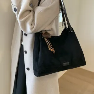 Detailed view of women's retro black suede shoulder bag, large capacity commuting handbag.