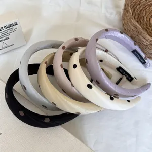 Dettaglio di cerchietti imbottiti in raso a pois in stile francese, eleganti accessori.