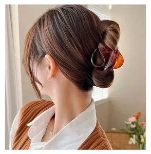 Pinza de pelo transparente grande en detalle, garra de resina ámbar para recogidos elegantes.