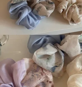 Detalle de coleteros de satén liso con estampados abstractos de acuarela en tonos pastel suaves.