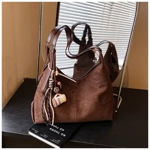 Retro brown suede shoulder bag for women, large capacity casual hobo tote with chic charms.