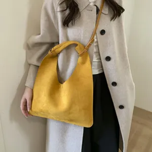 Yellow suede hobo shoulder bag featuring a unique knotted handle design and large capacity.