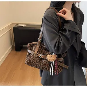 Leopard print shoulder bag detail view with brown straps and cute bear pendant accessory.