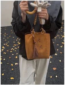 Nahaufnahme Detail der Damen braune Wildleder Beuteltasche mit funkelnden Strass Schleifen.