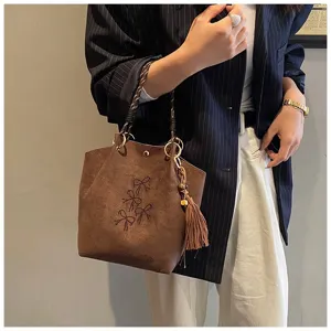 Elegante Damen Wildleder Beuteltasche mit Strass-Schleife, geflochtenem Griff und Quaste.