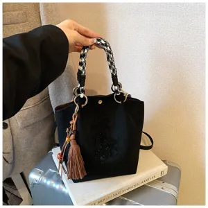 Detailansicht der schwarzen Wildleder Beuteltasche für Damen mit Hahnentritt-Griff und Quaste.