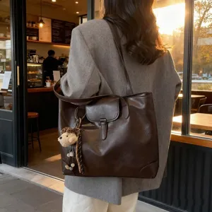Classic brown large capacity leather tote bag with cute bear pendant for daily commute style.