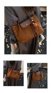 Brown suede tote bag detail featuring stylish flap closure and cute pendant charm outdoors.