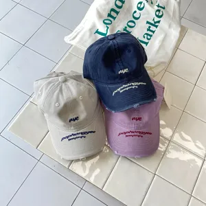 Cappello da baseball lavato con lettere ricamate, corona morbida per uno stile casual.