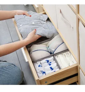 Organizador de cajones de tela con compartimentos para el almacenamiento ordenado de ropa.
