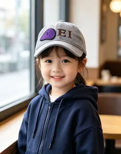 Close-up of grey corduroy kids baseball cap with cute embroidered letters and patch.