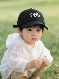 Cute kids baseball cap detail showing funny big eyes embroidery and soft black fabric.