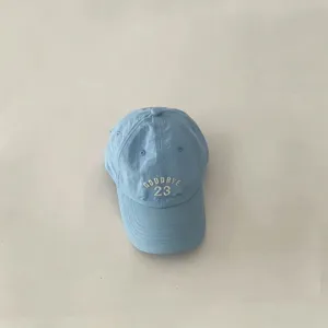 Close-up detail of light blue kids baseball cap featuring front embroidery and breathable fabric.