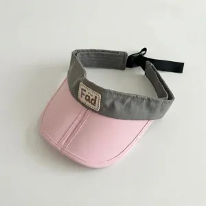 Detail view of a stylish color-block kids sun visor, featuring a pink brim and adjustable strap.