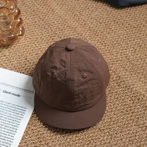 Close-up detail of a brown quick-drying short brim baseball cap, breathable outdoor casual hat.