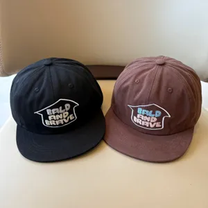 Detalle de gorra de béisbol para niños, diseño de verano en negro y marrón con visera.