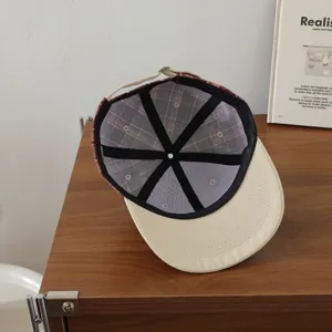 Vista detallada del gorro a cuadros para niños con forro de malla interior transpirable.