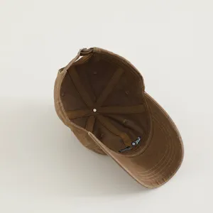 Children brown baseball cap interior detail view showing lining and adjustable strap.