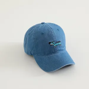 Details of the kids denim baseball cap featuring a cute embroidered puppy and washed blue fabric.