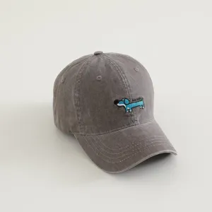 Detail shot of grey washed kids baseball cap with cute blue dog embroidery and curved brim.