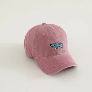 Kids pink washed baseball hat detail showing cute puppy embroidery and premium cotton fabric.