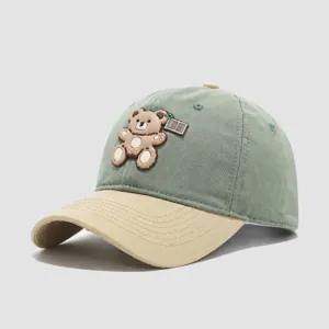 Cute cartoon bear patch detail on kids baseball cap, breathable cotton material, green and beige.