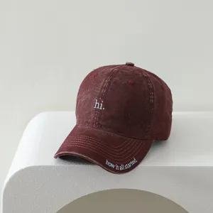 Close-up detail view of kids vintage washed baseball cap with letter embroidery and brim text.